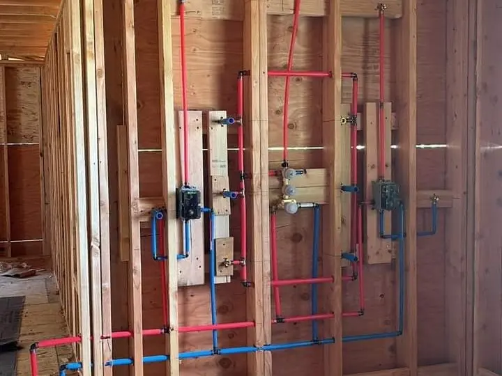 Open wall framing with red and blue PEX lines