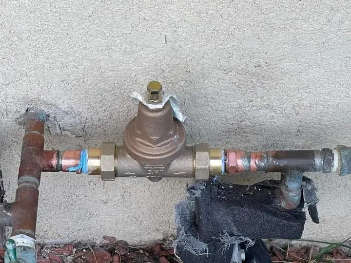 Pressure regulator on an exterior wall with new copper piping